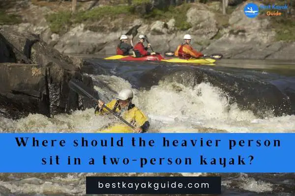 Where should the heavier person sit in a two-person kayak?